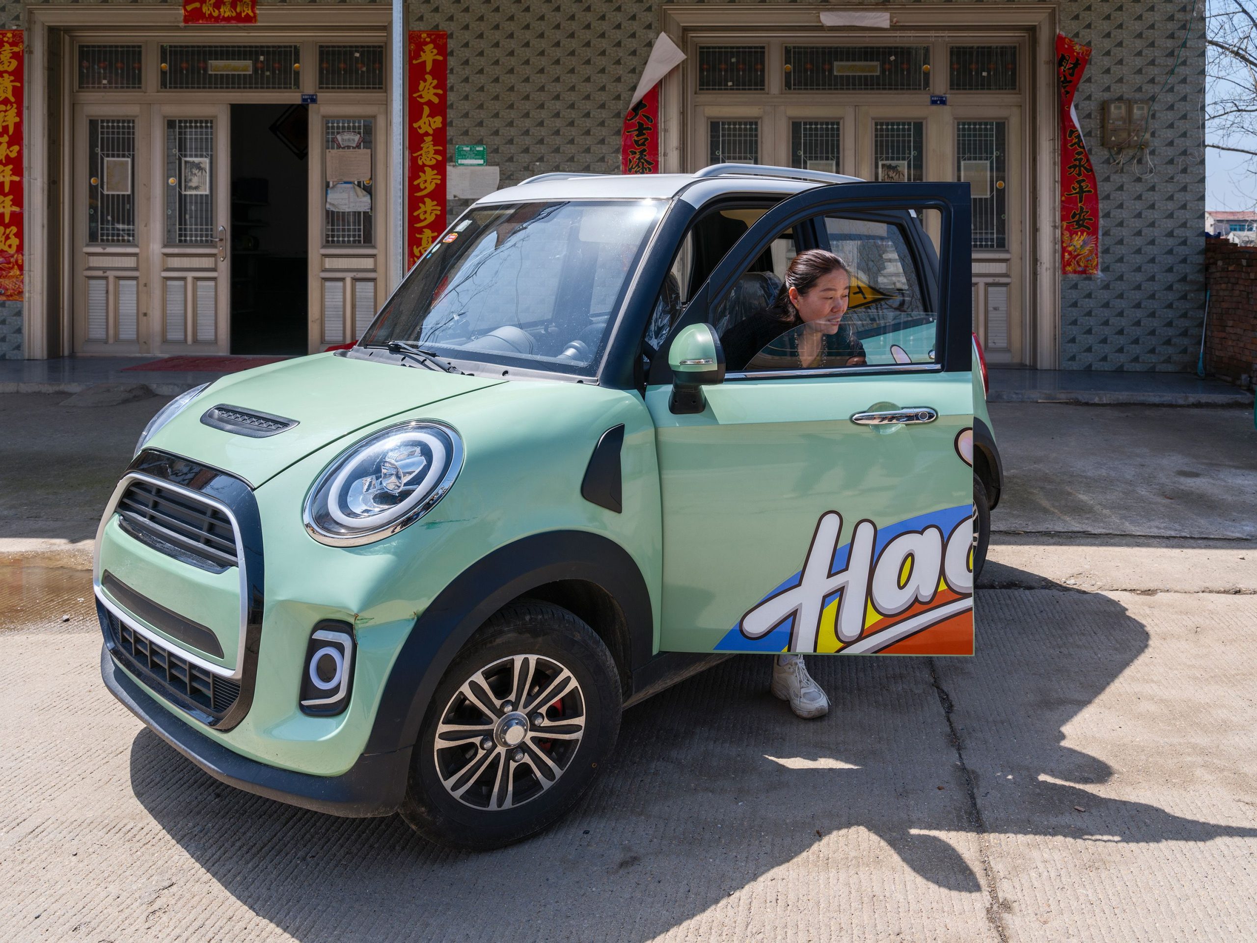 Jeune femme sortant d'une Reva électrique colorée