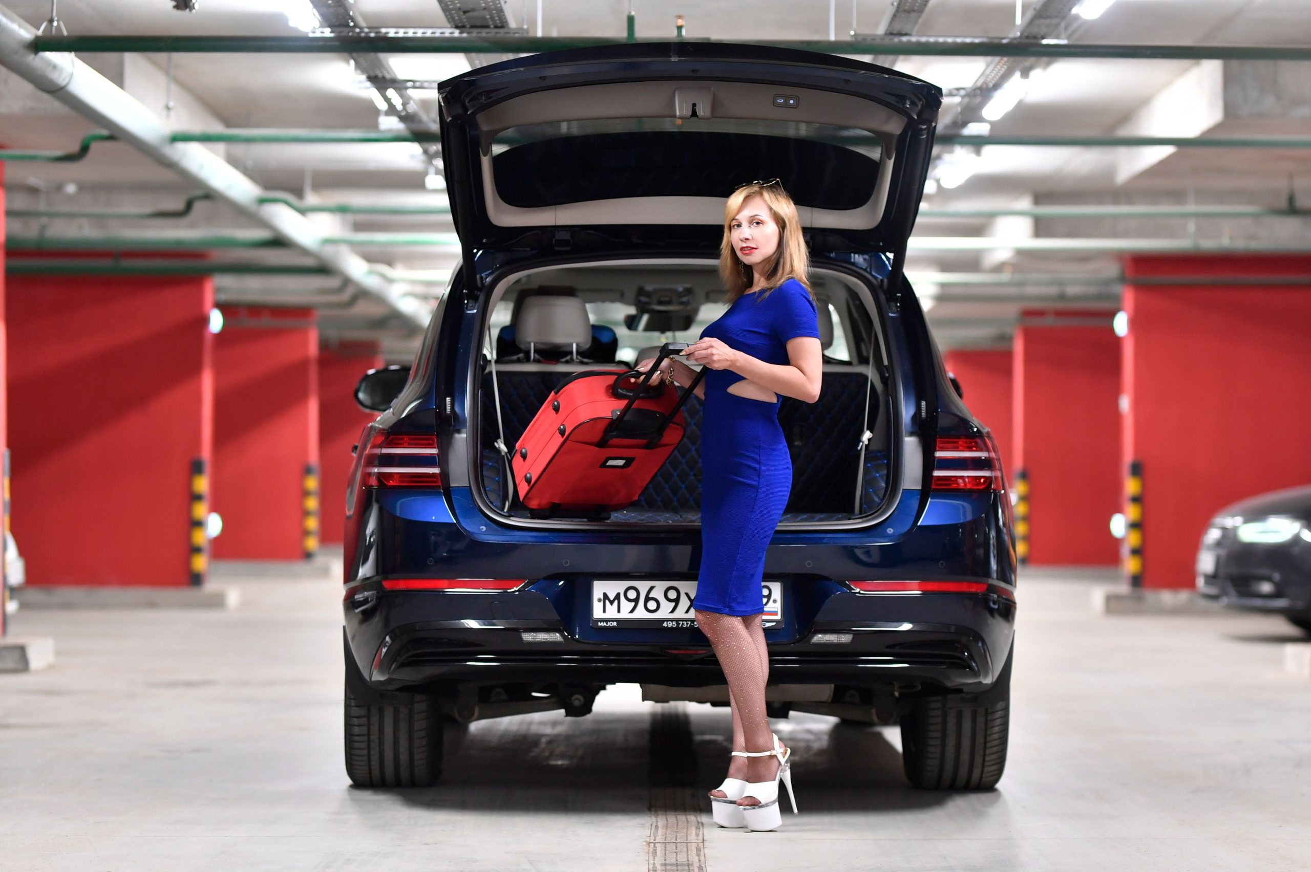 Femme chargeant valises dans coffre automobile