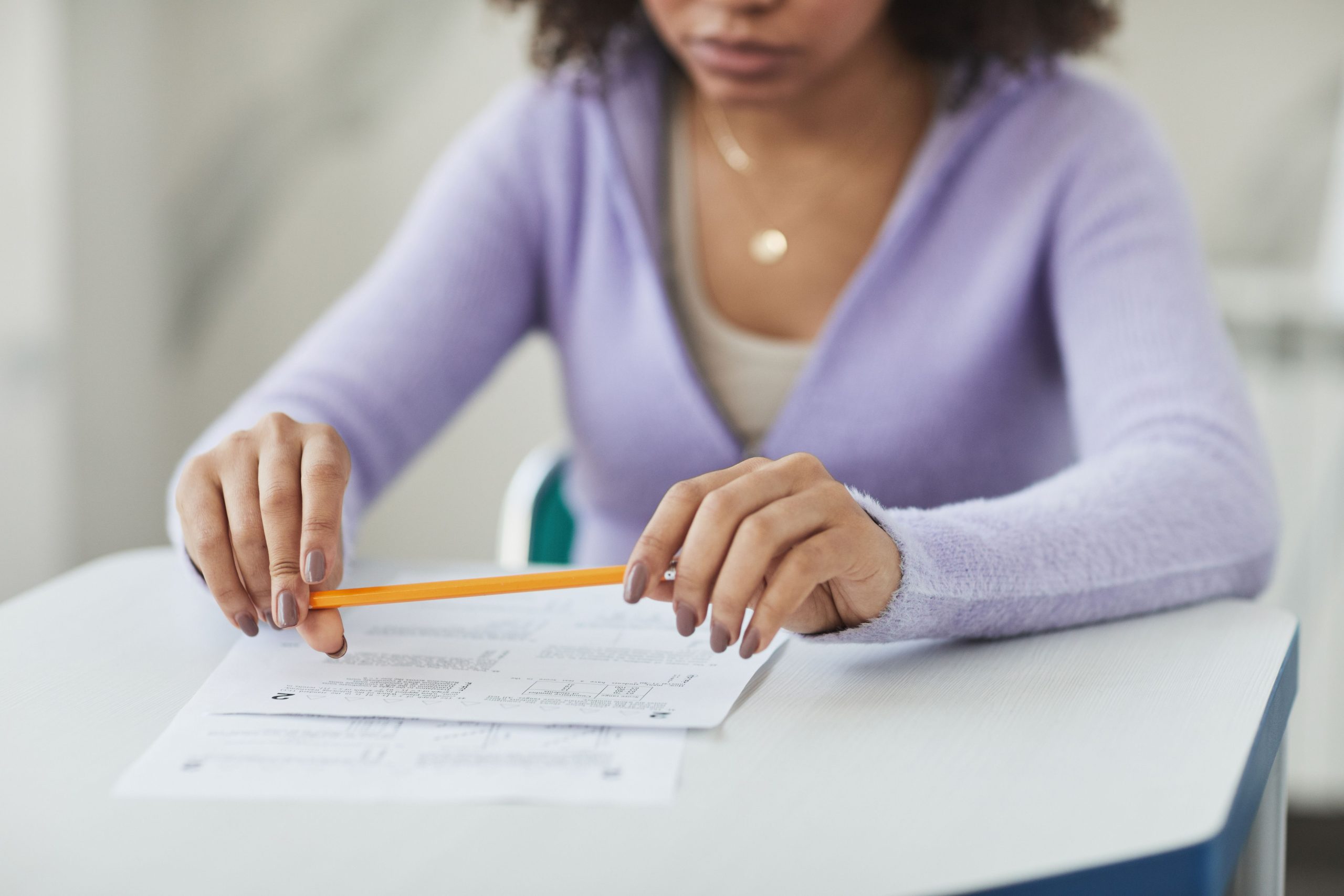 Étudiant concentré tenant un crayon et une feuille d'examen