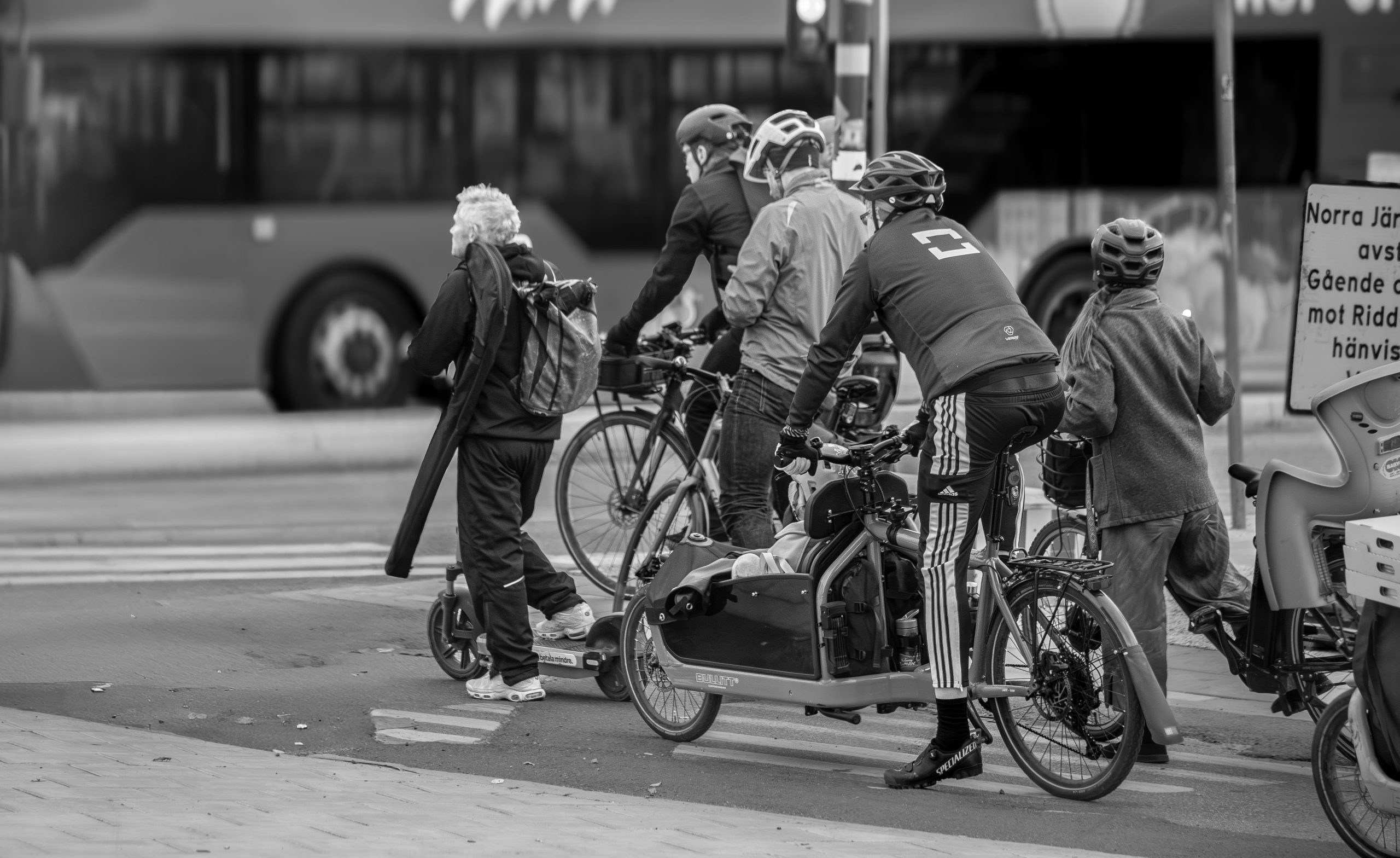 Cyclistes et utilisateurs scooter attendent au feu