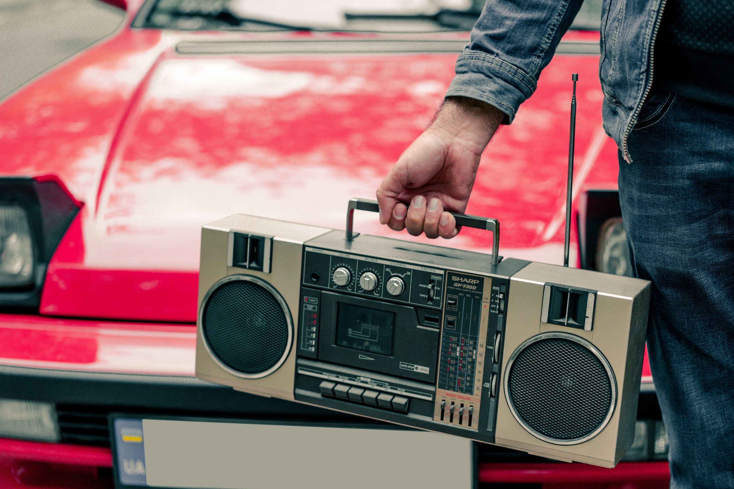 Homme cassette rétro devant voiture classique