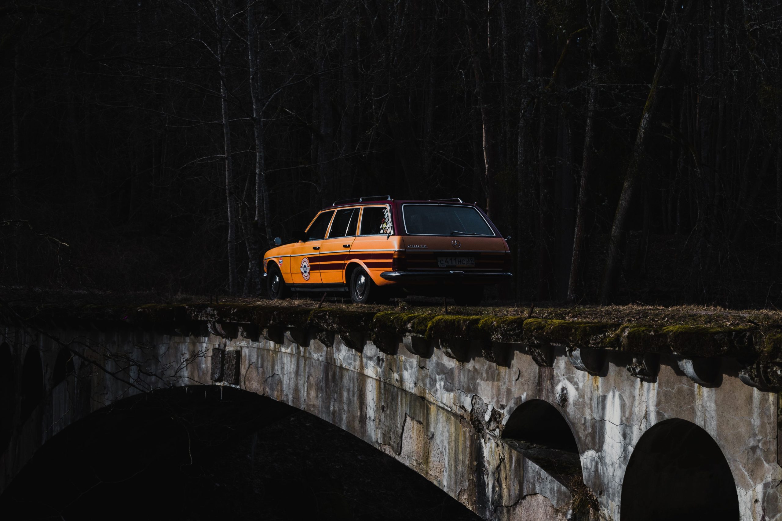 Mercedes station wagon jaune vintage sur pont pierre
