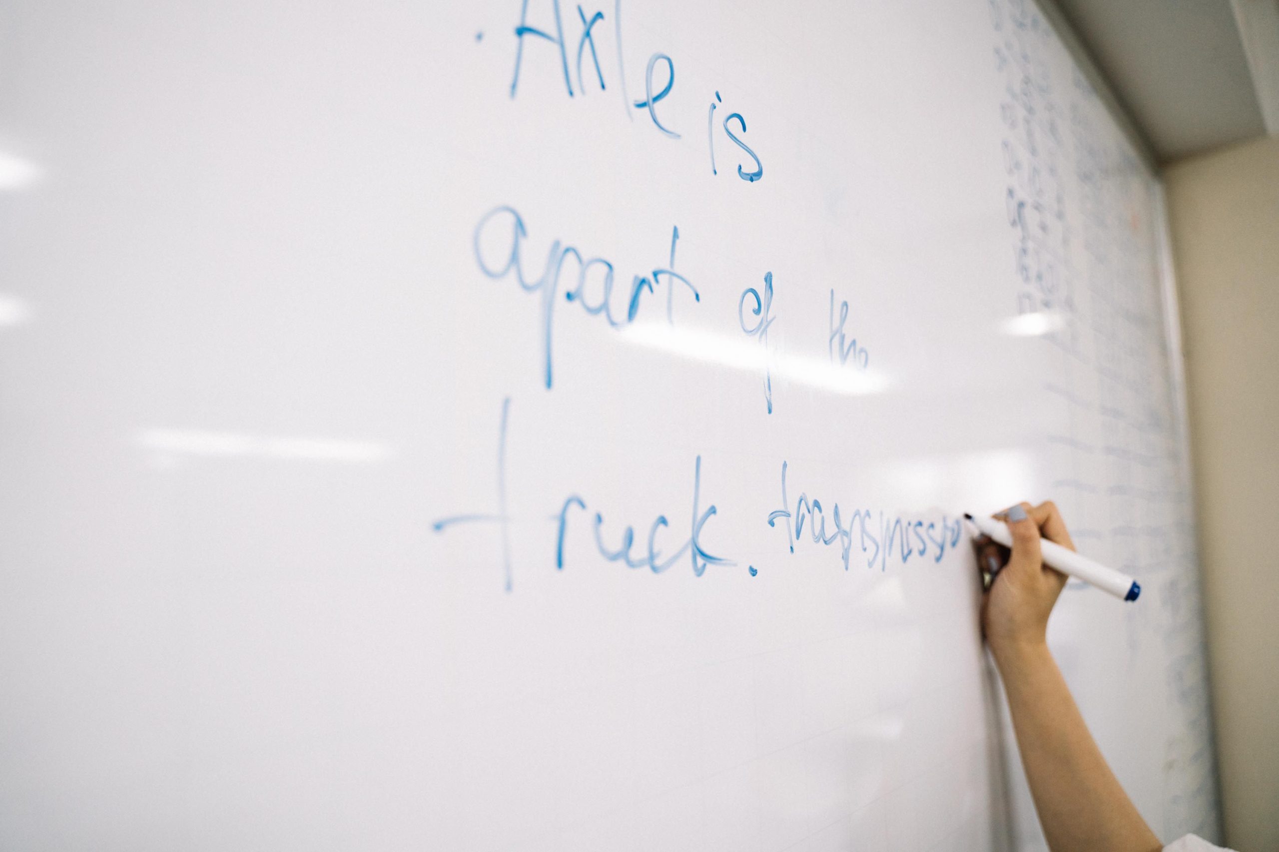 Personne ecrivant des notes educatives sur un tableau blanc