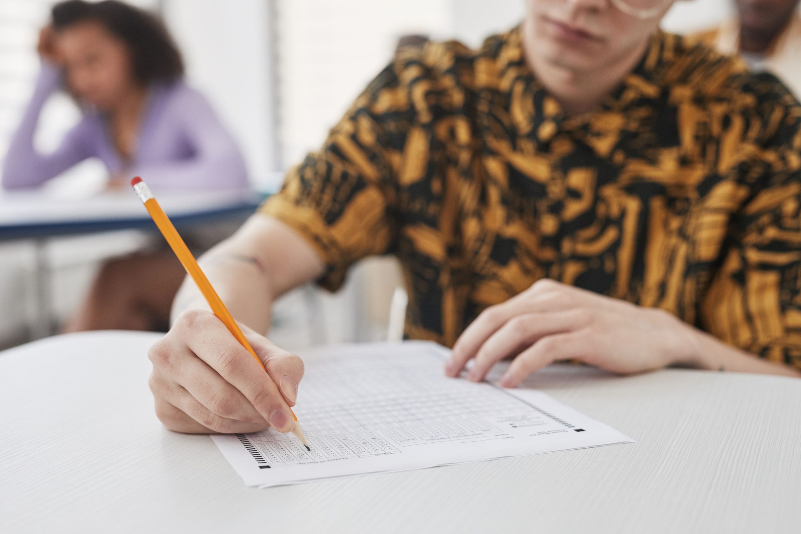 Jeune adulte écrivant sur une feuille d'examen