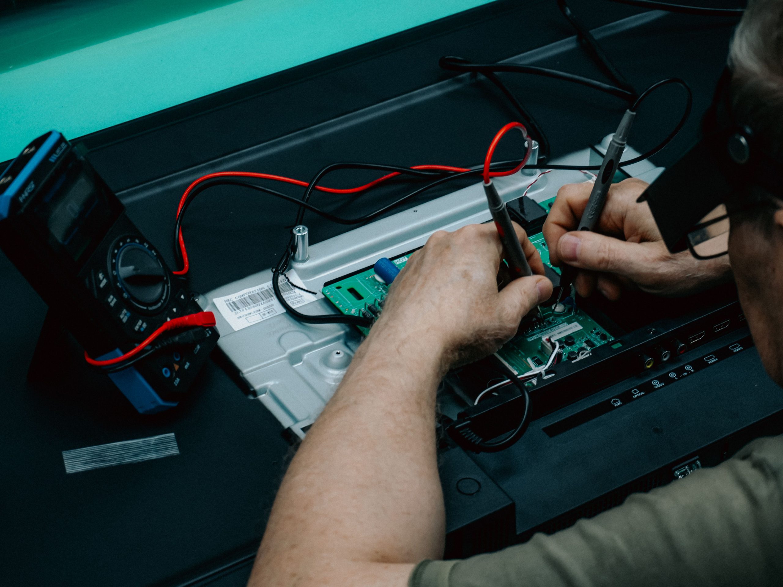 Technicien utilisant multimètre pour diagnostic électronique