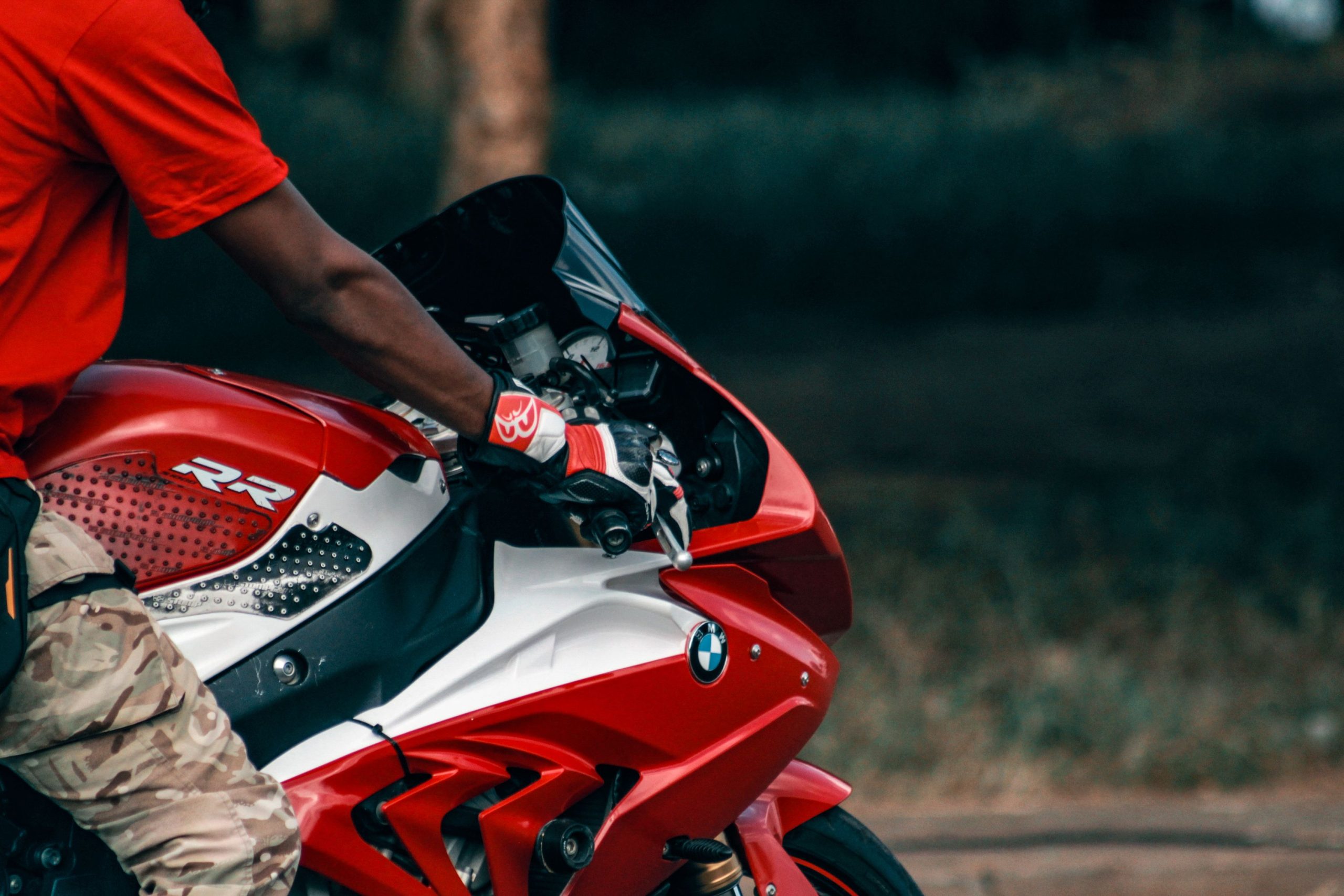 Gros plan d'un motard sur une BMW rouge
