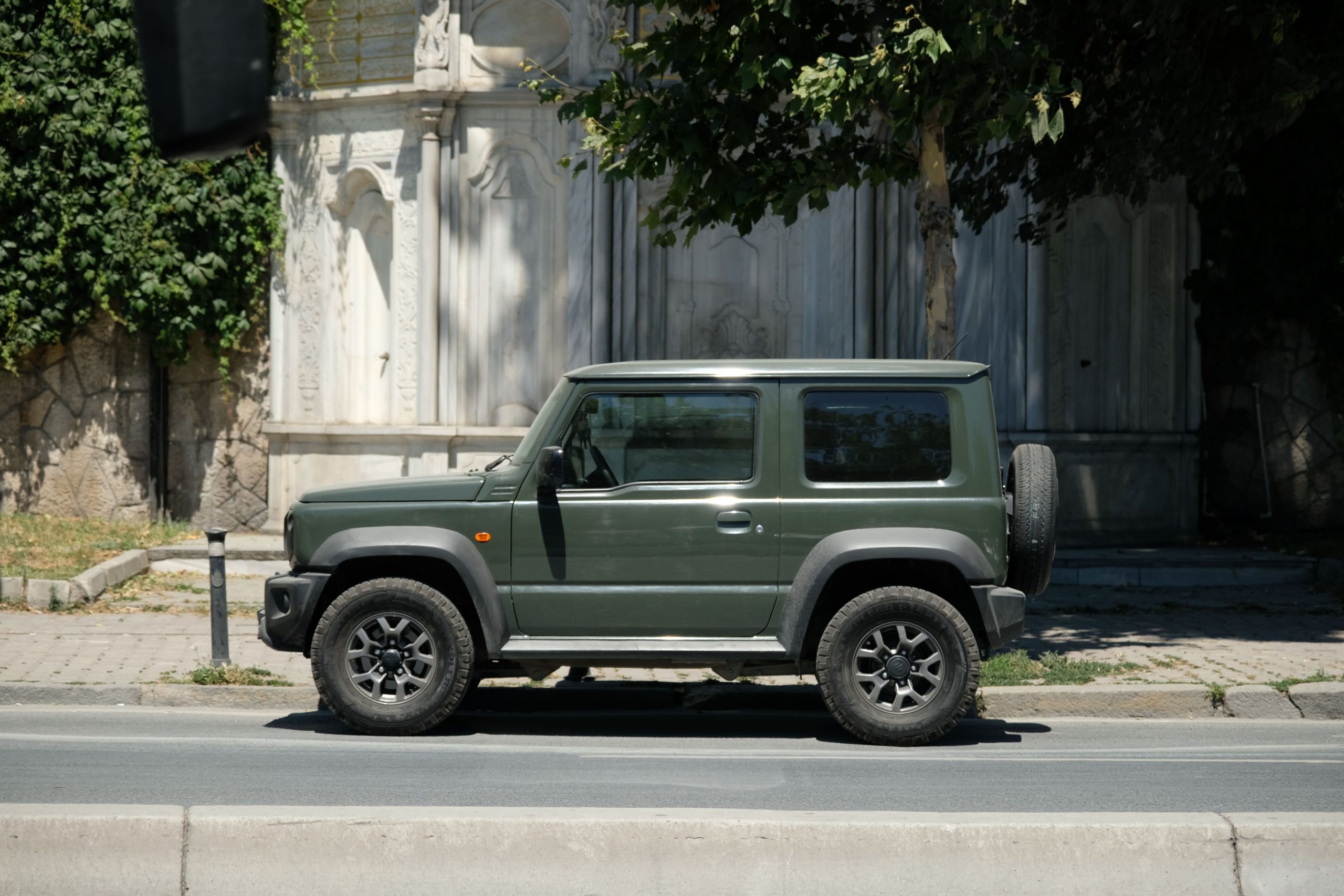 4x4 vert garé dans une rue urbaine ensoleillée