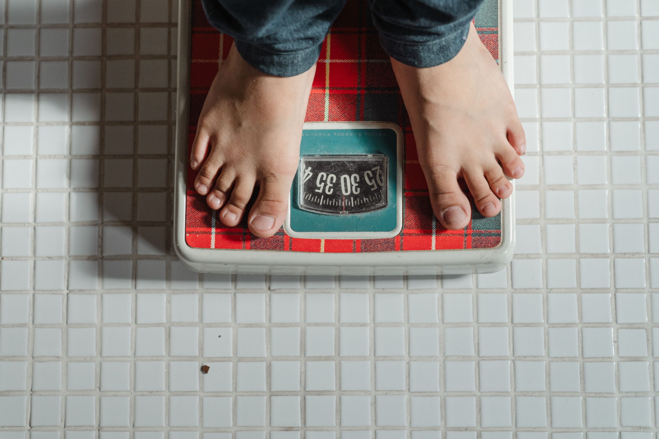 Enfant pieds nus debout sur une balance