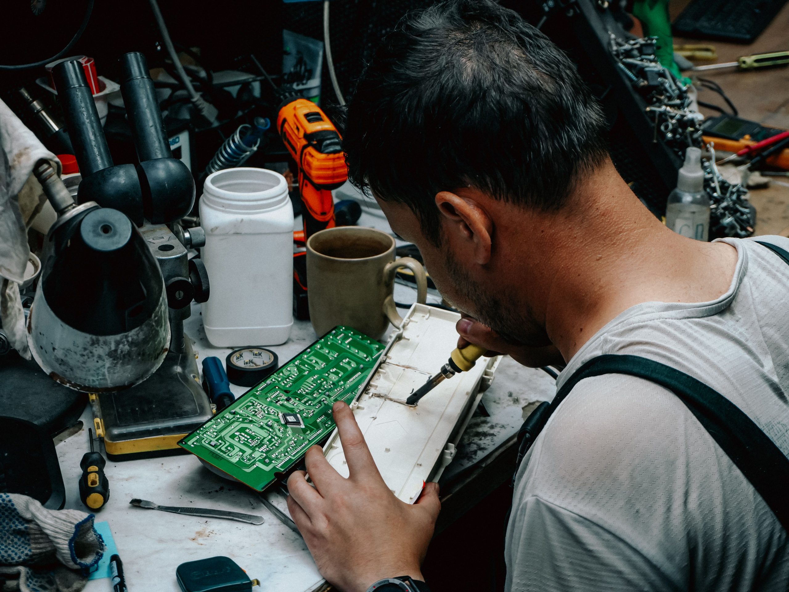 Technicien soudant circuit imprimé en atelier